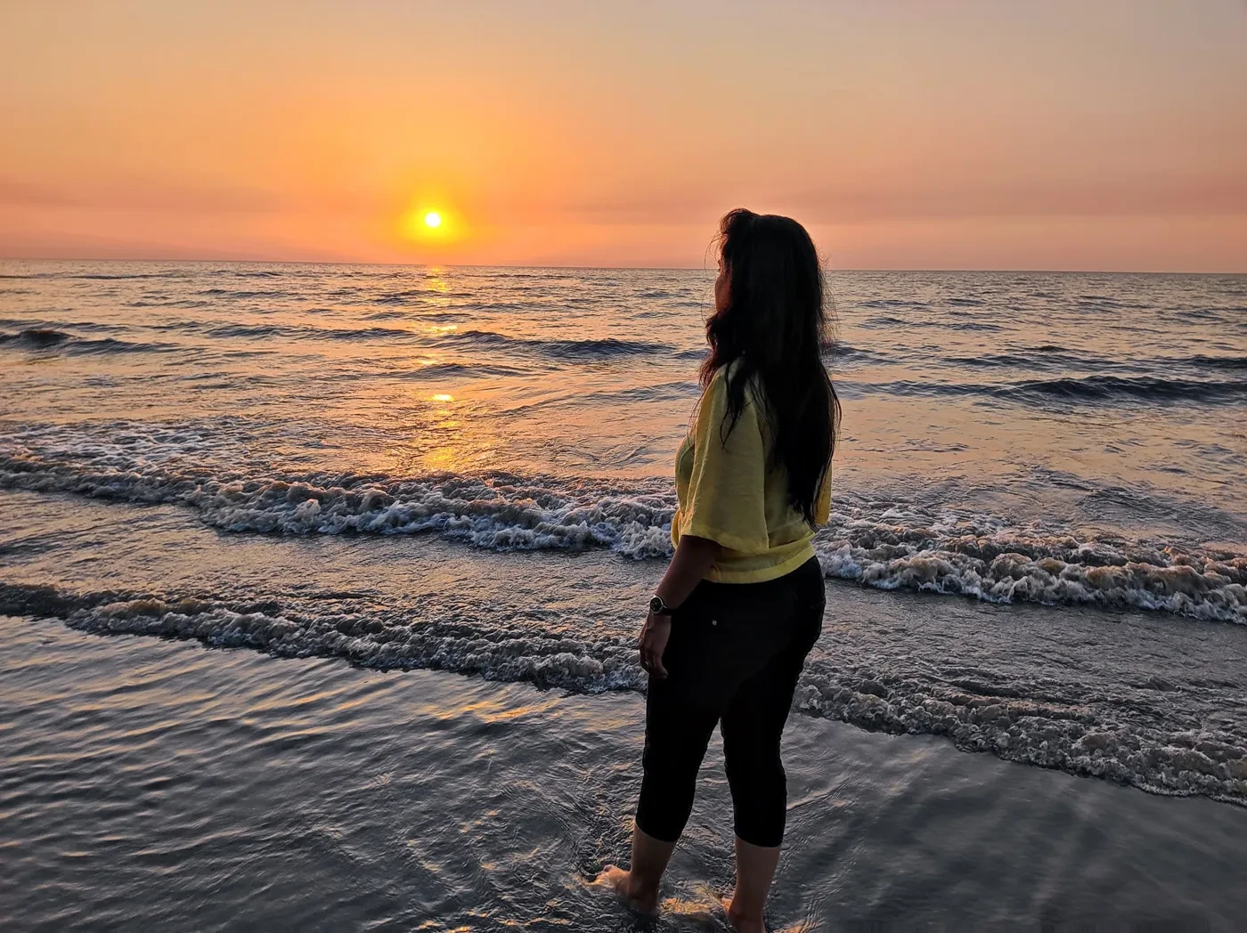 Poonam watching the sunset on the beach at Daman