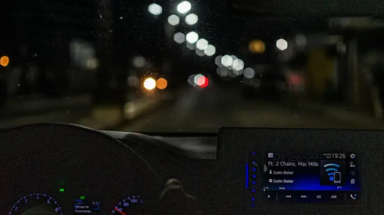 Car infotainment screen playing music for the perfect road trip playlist.
